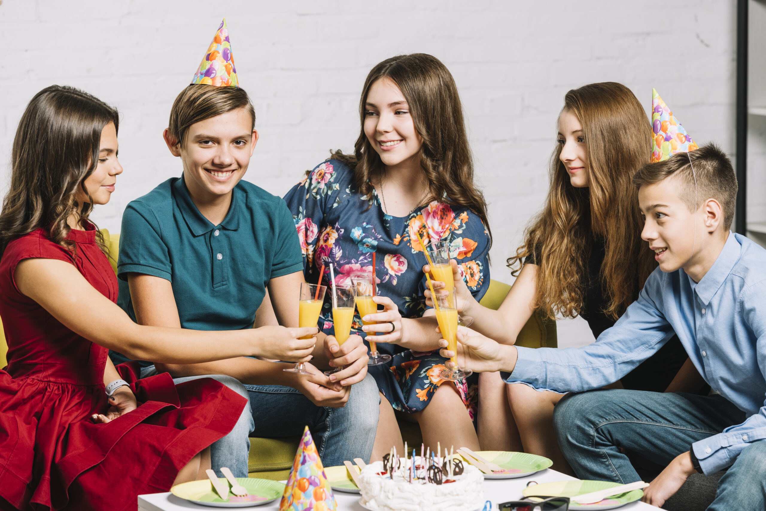 group-happy-friends-looking-birthday-boy-holding-glasses-juice-party